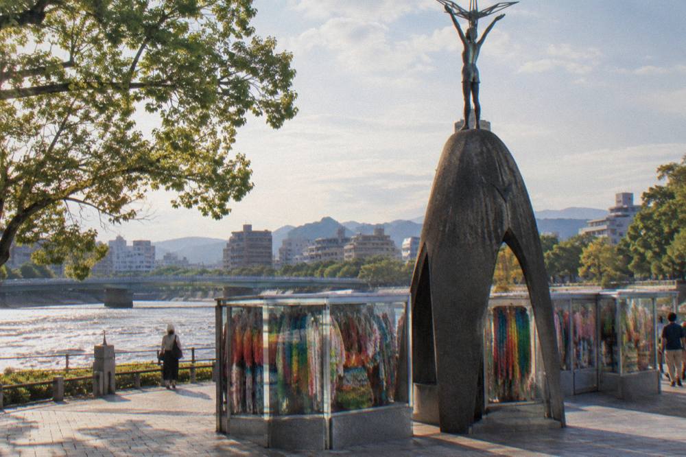 Paper cranes hanging in glass cases at the Children's Peace Monument in Hiroshima