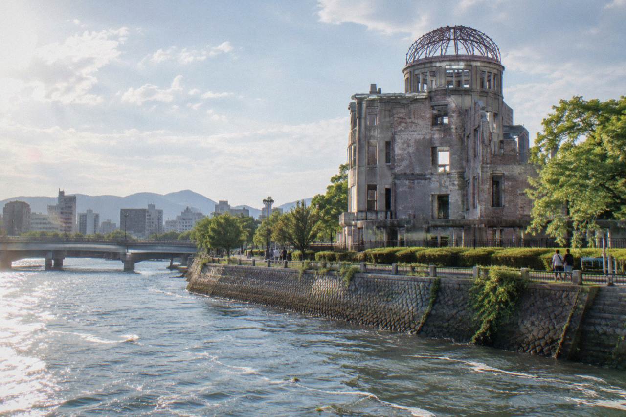 The Peace Memorial Park in Hiroshima with green lawns, the A-Bomb Dome and the Ota River in the foreground