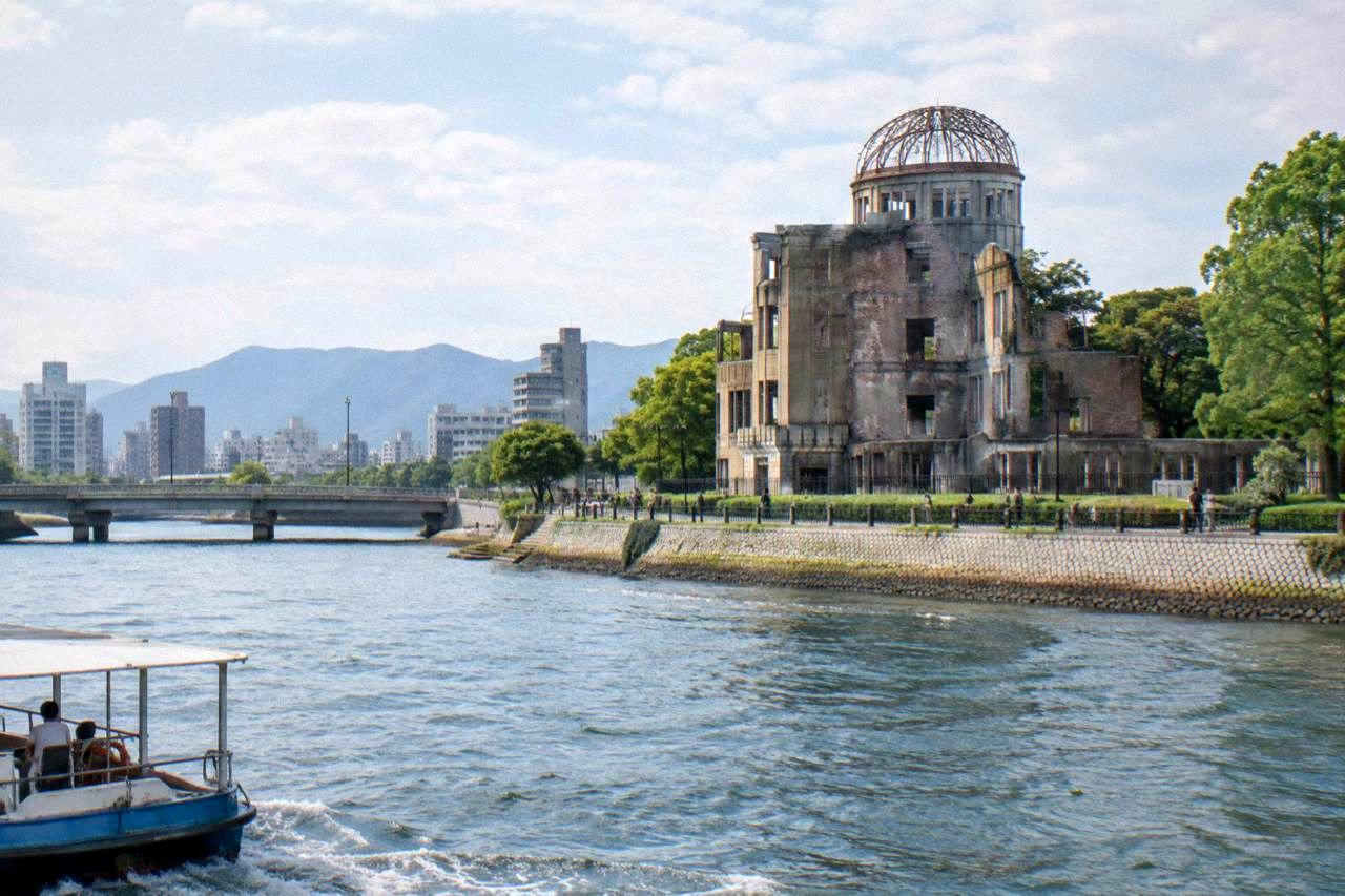 The A-Bomb Dome in Hiroshima Peace Memorial Park seen across the Motoyasu River in morning light