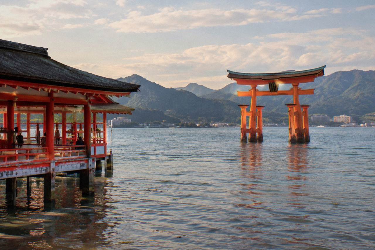 The Great Torii of Itsukushima Shrine standing in the water at Miyajima with warm evening light on its pillars