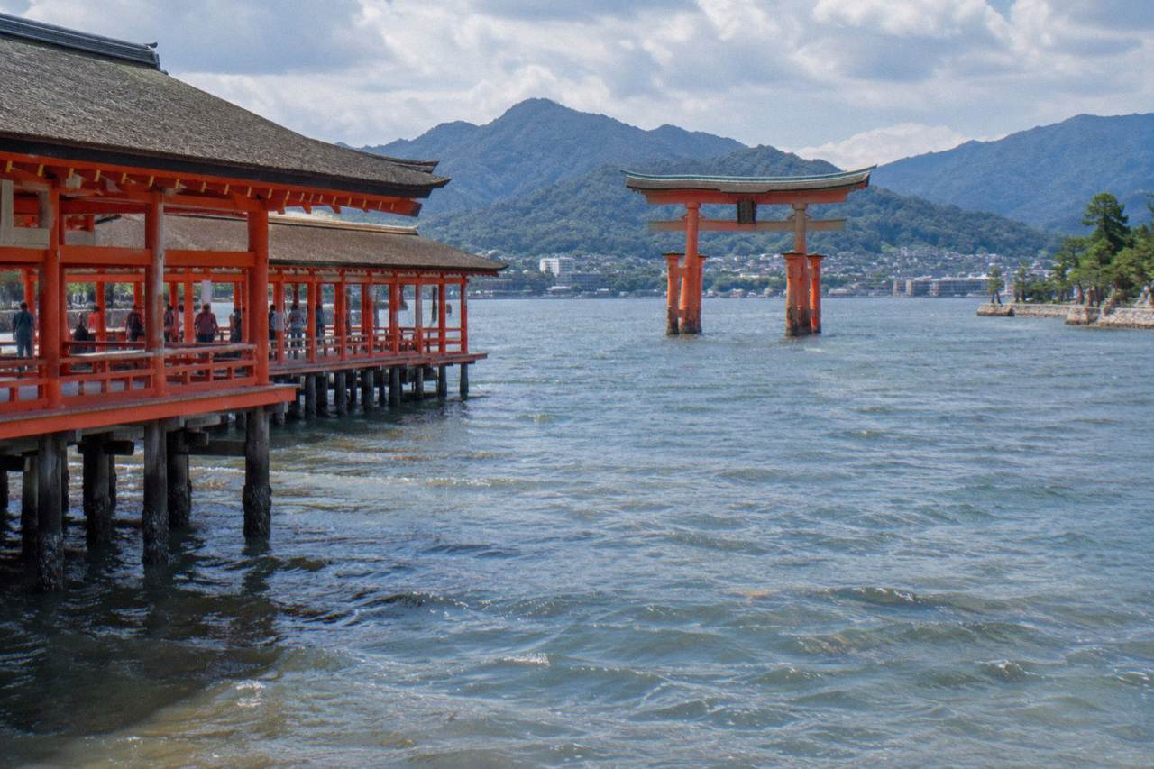 The red Great Torii of Itsukushima Shrine standing in the shallow water of Hiroshima Bay at Miyajima