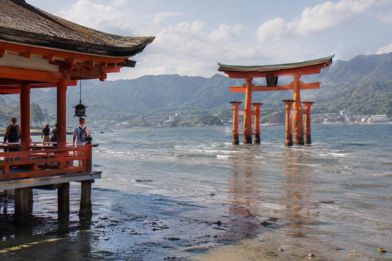 The Great Torii of Itsukushima Shrine standing in shallow water at low tide on Miyajima