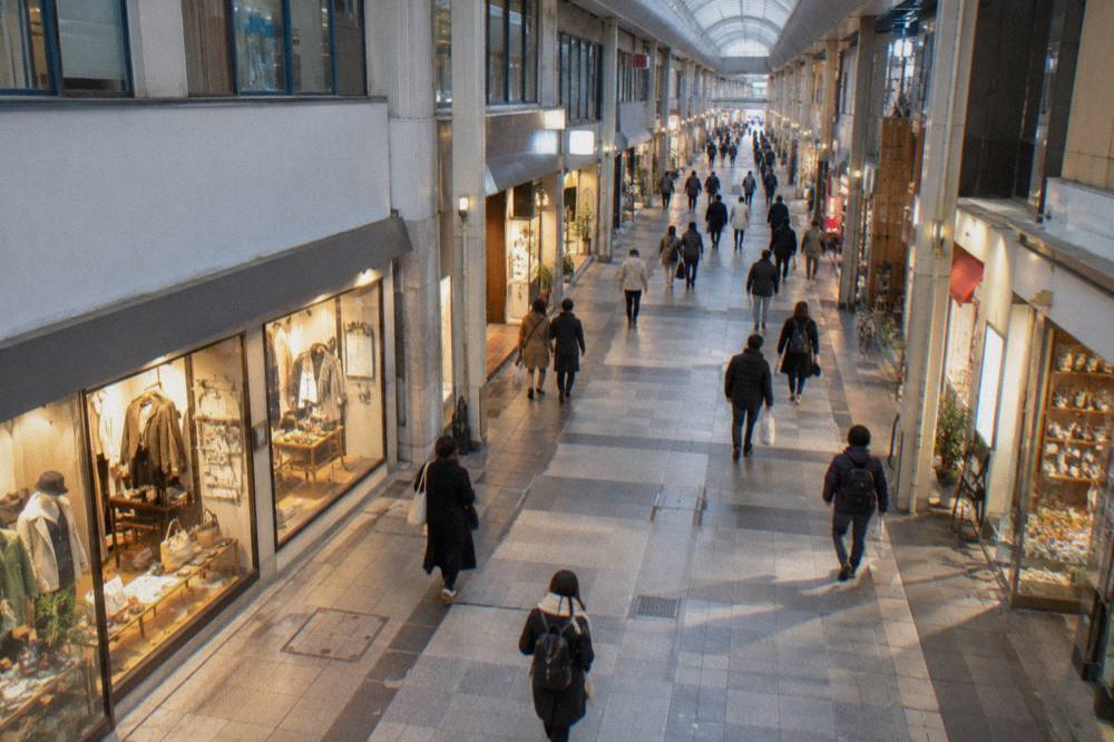 Covered shopping arcade in central Hiroshima with lit shopfronts in the evening