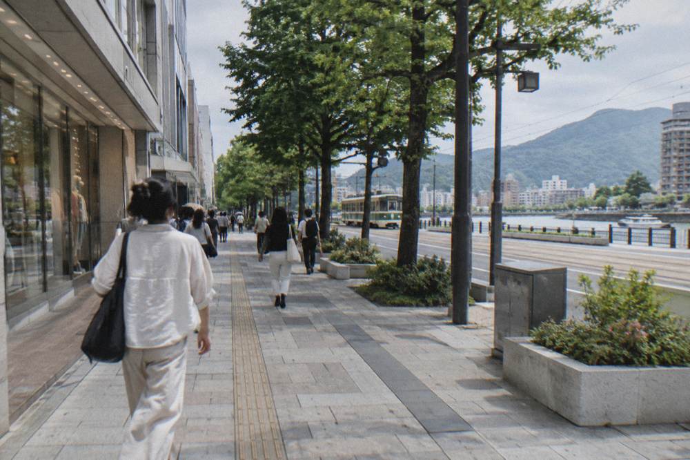 Busy shopping street in Hiroshima with department store facades in daylight