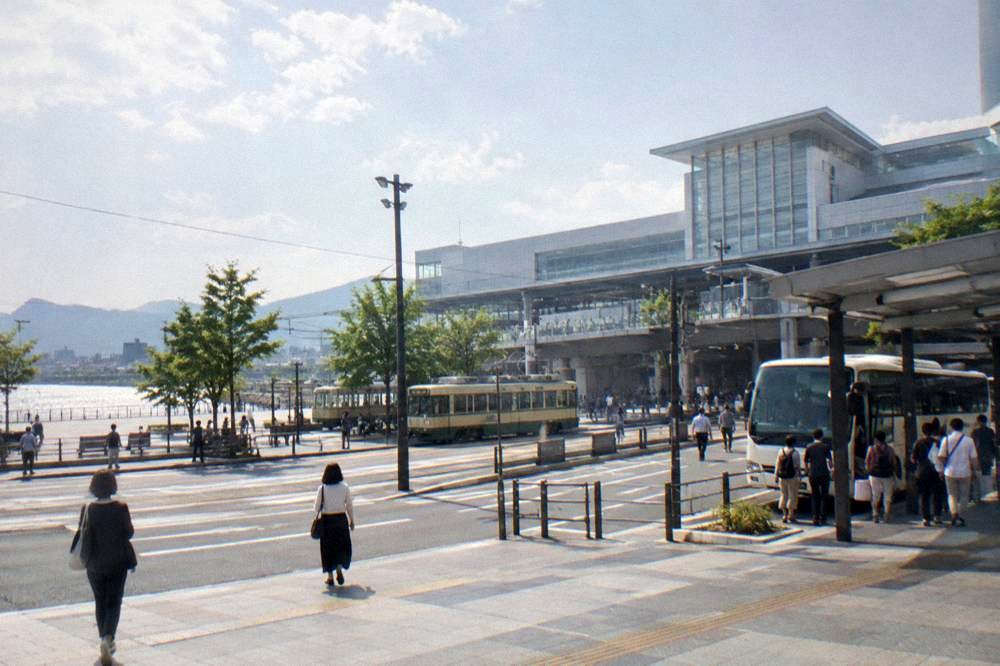 An airport limousine bus parked at a covered stop with passengers boarding