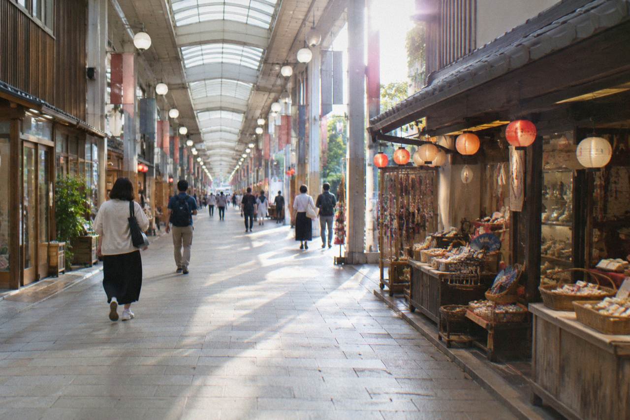 A covered shopping arcade on Miyajima island with small shops and lanterns along the walkway