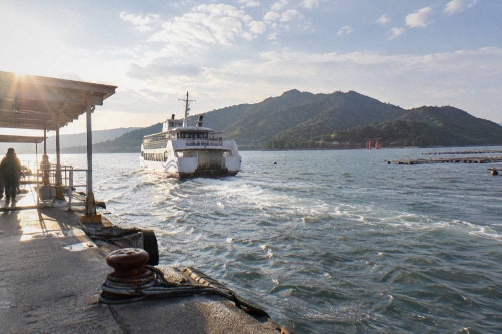 Large ferry departing Miyajimaguchi pier heading toward the Great Torii of Miyajima