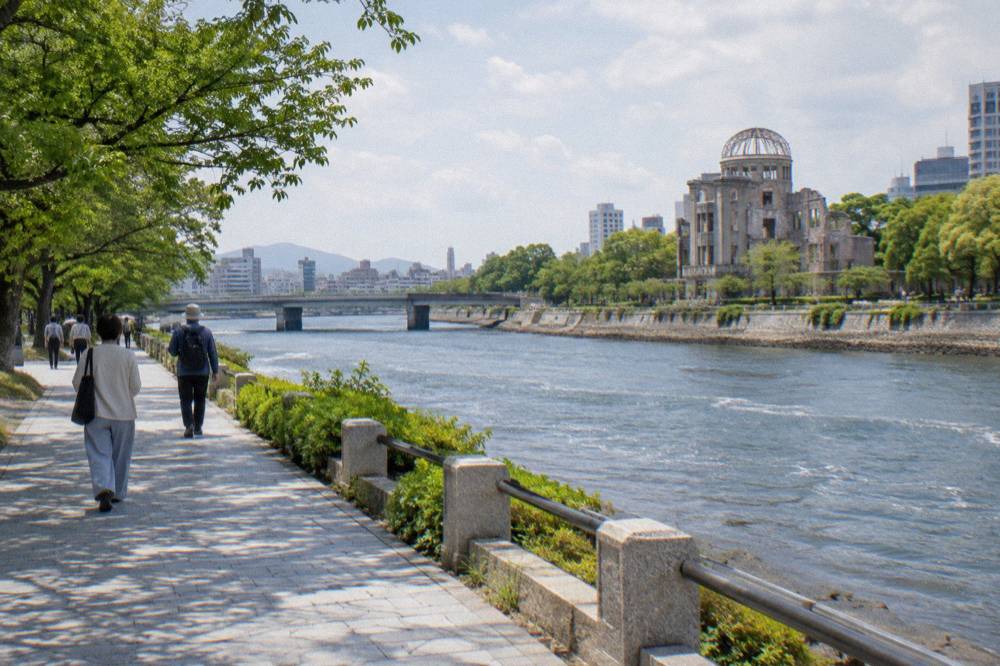 Visitors walking quietly along a tree-lined path in Peace Memorial Park in Hiroshima