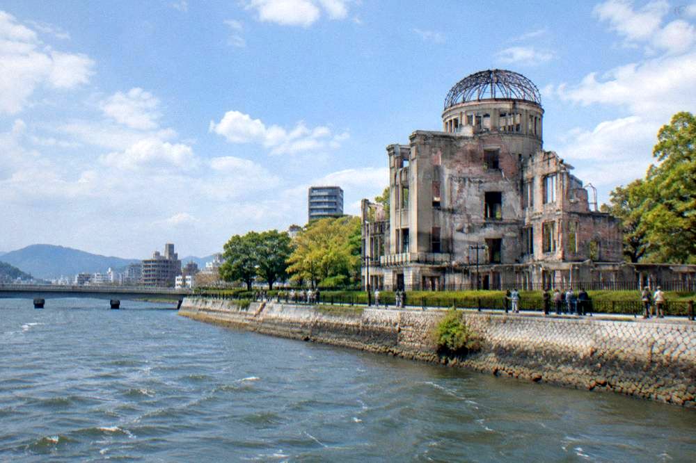 Visitors standing quietly at the fence around the Atomic Bomb Dome