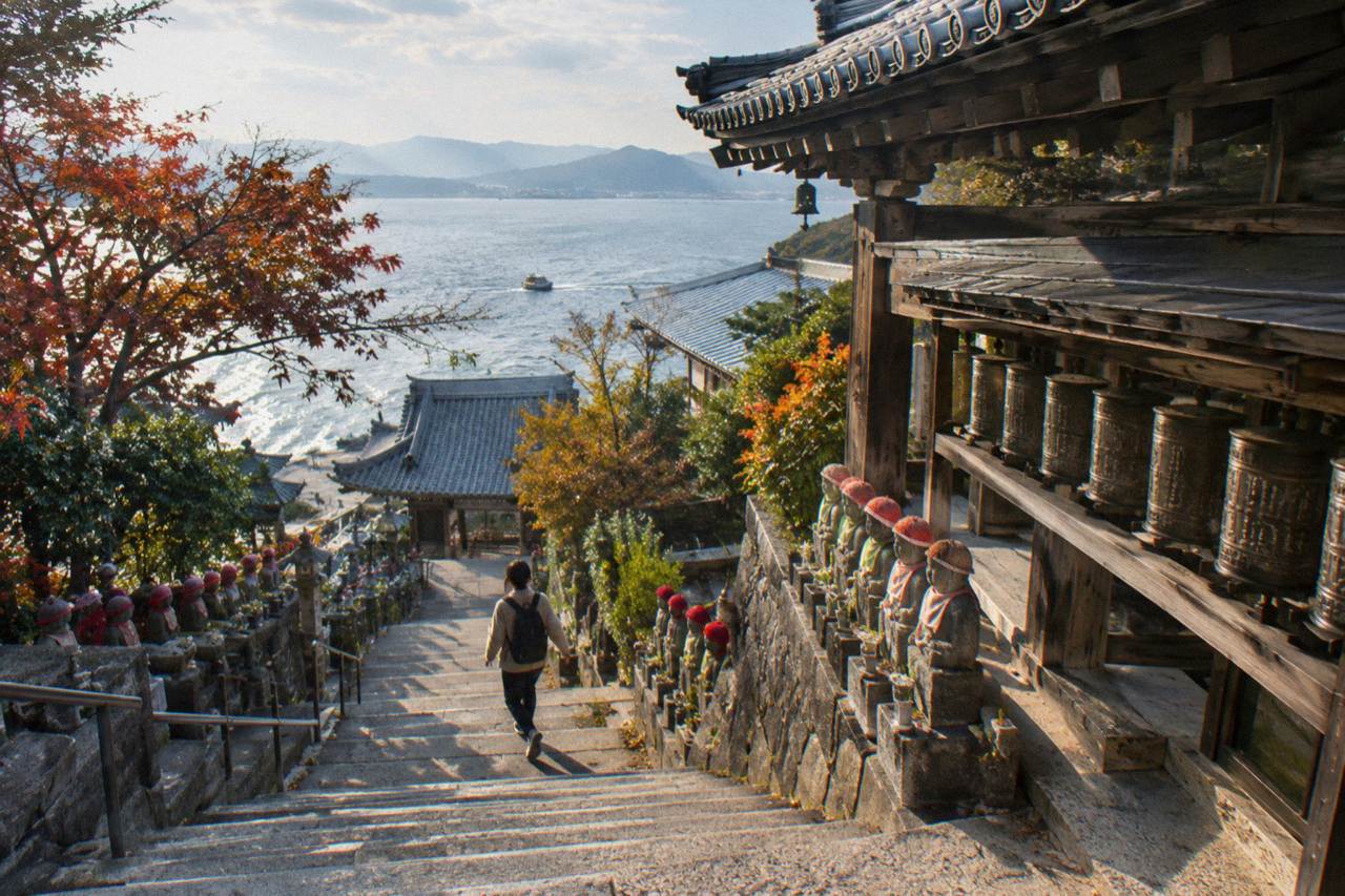 Stone steps lined with small Buddhist statues leading up to Daisho-In Temple on Miyajima island