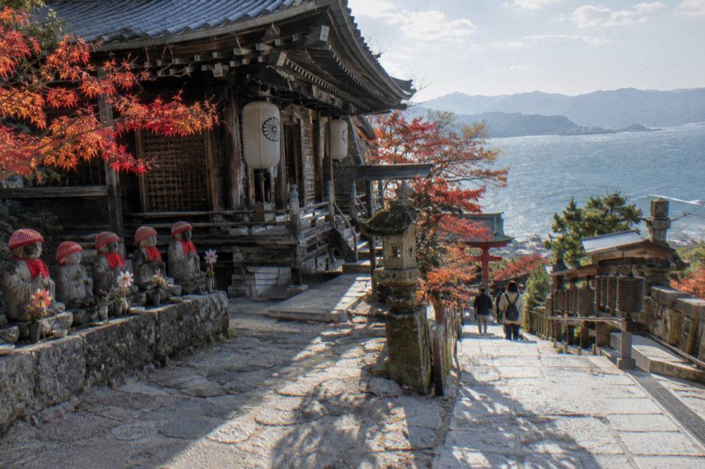 A wooden temple hall with paper lanterns and a stone path at Daisho-In Temple