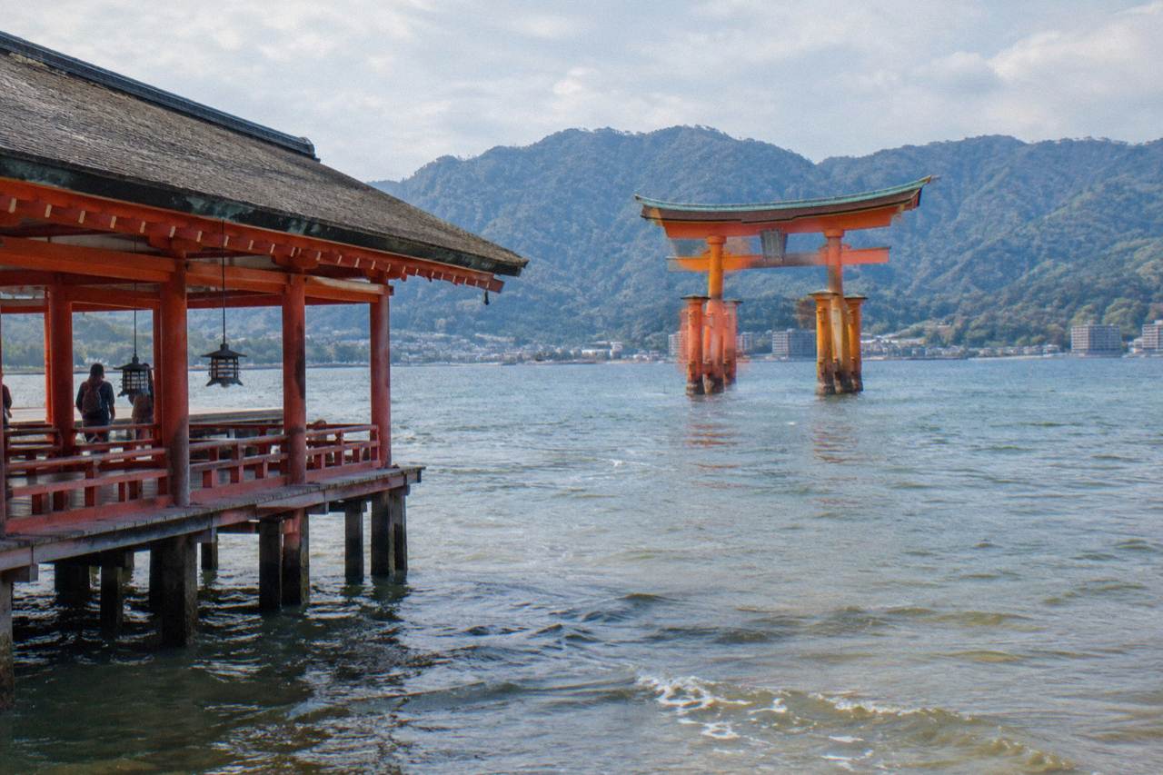 The red Great Torii gate of Itsukushima Shrine standing in the shallow water of Hiroshima Bay at Miyajima