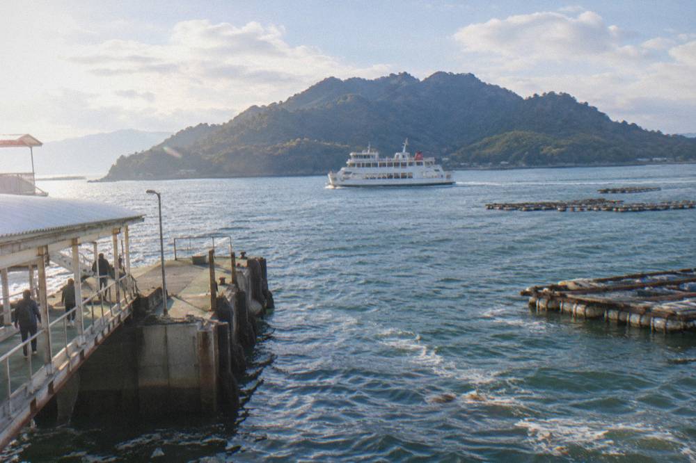 A white ferry crossing the short stretch of water between Miyajimaguchi and Miyajima island