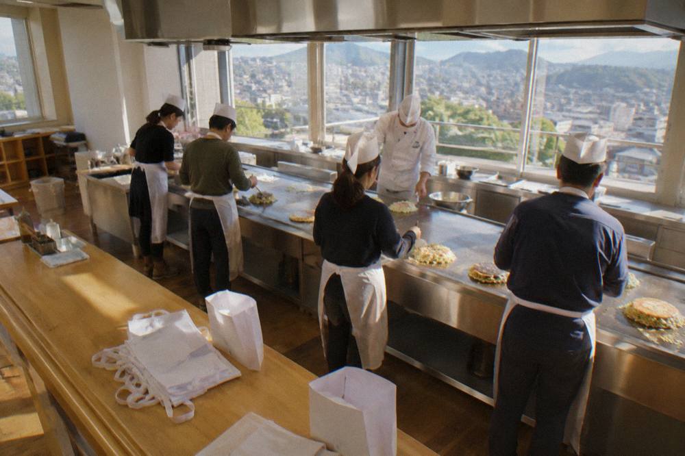 A paper apron and paper hat souvenirs folded on a workshop counter