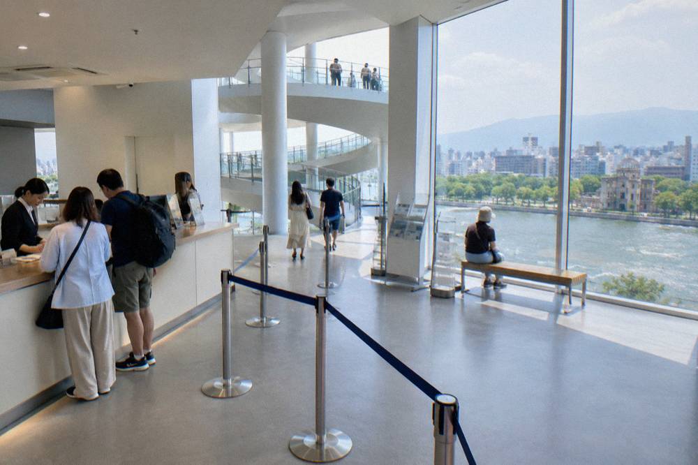 A ticket counter in a bright modern lobby with staff serving visitors