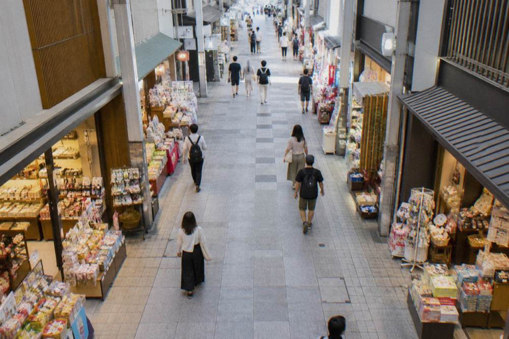 A shop interior in a covered arcade with souvenirs and snacks displayed along both walls