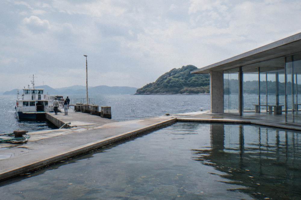 A quiet reflecting pool inside a gallery with soft daylight from a skylight