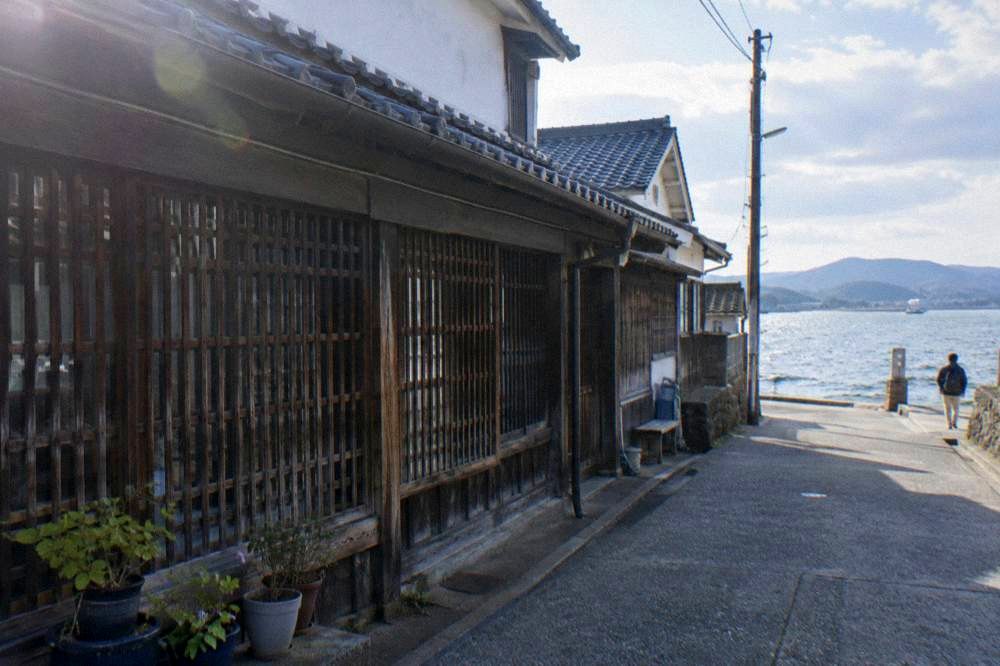 Latticed storefront of an old wooden merchant house along a narrow lane