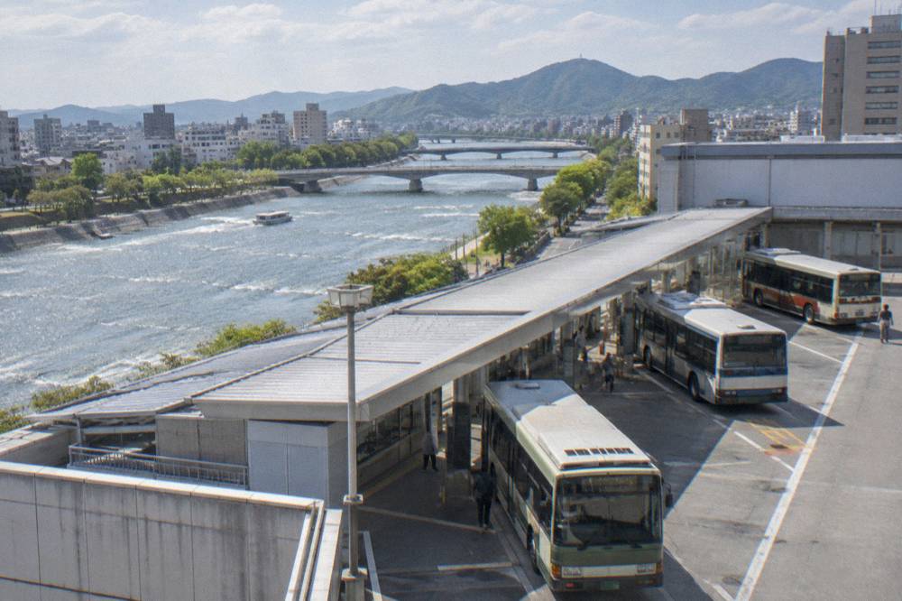 A city bus terminal on the upper floor of a department store building with buses at bays