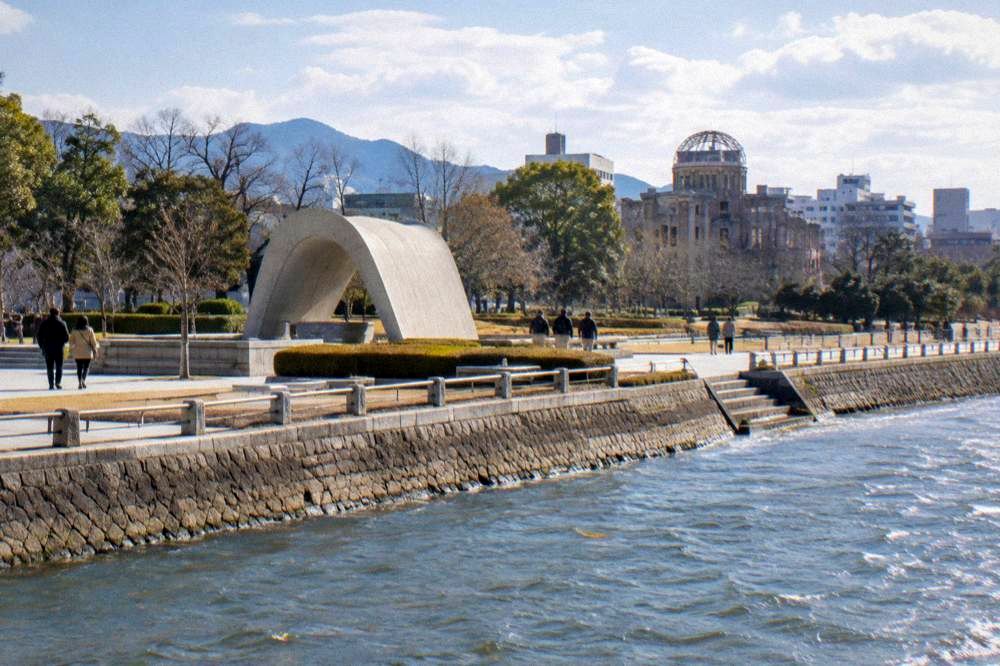 The arched Cenotaph for the A-bomb Victims in Hiroshima Peace Memorial Park seen from the path