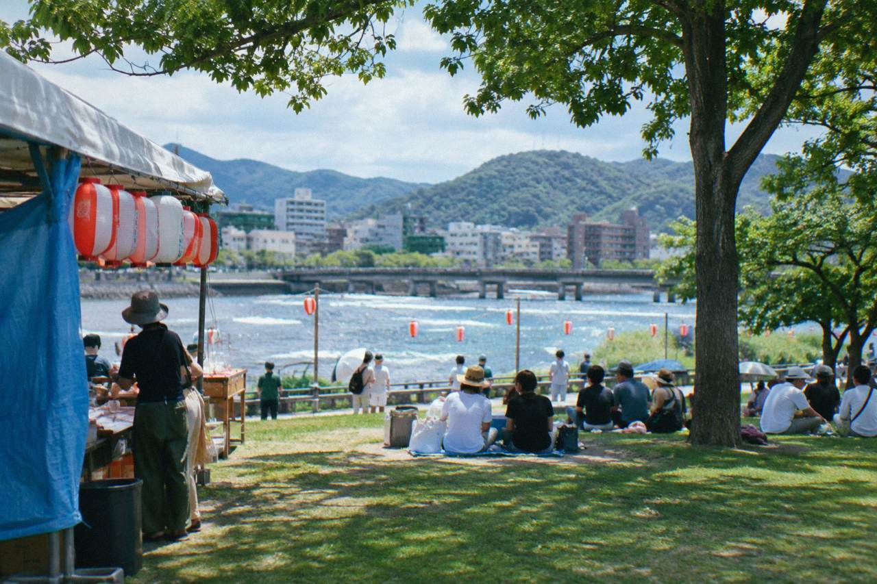 Crowds gathered in a riverside park in Hiroshima during a summer festival day