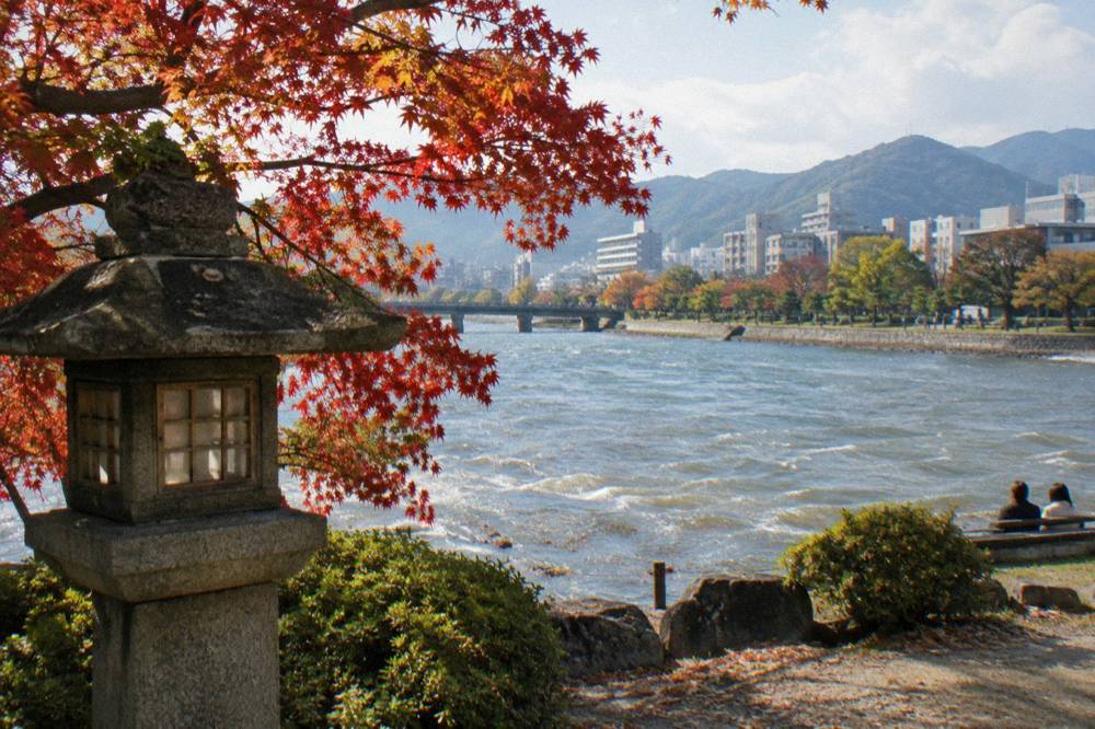 Red maple branches over a stone lantern in a Hiroshima garden