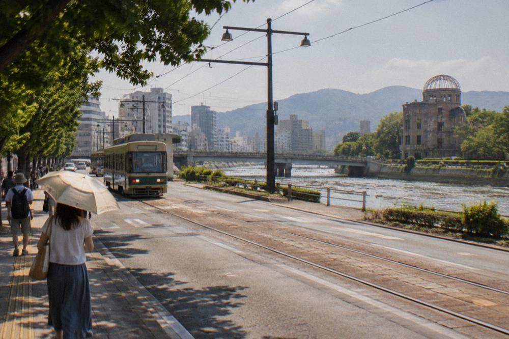 A sunlit street in downtown Hiroshima with heat haze over the tram tracks