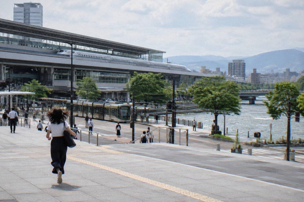 A white bullet train at an elevated platform of Hiroshima Station