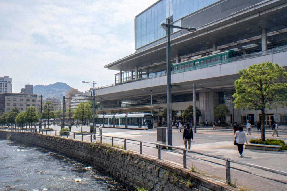 A green Hiroden streetcar at the elevated tram terminal inside Hiroshima Station