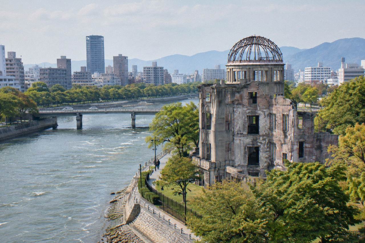 Modern Hiroshima skyline with the Atomic Bomb Dome in the foreground by the river