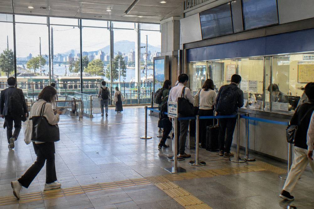 A ticket counter at Hiroshima Station with a small queue of travellers