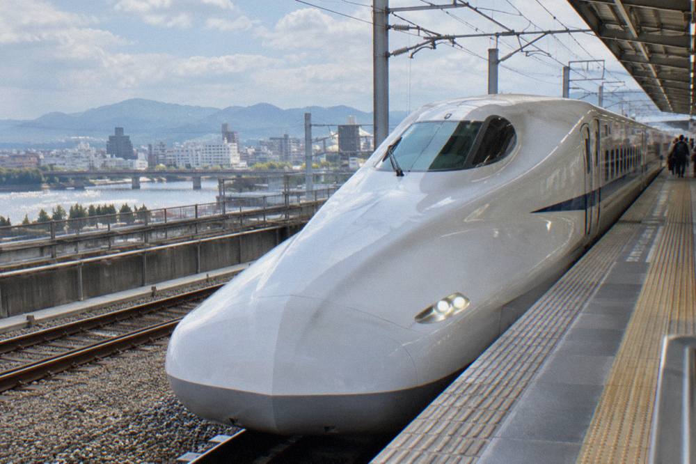 A sleek shinkansen bullet train waiting at a platform in a Japanese station