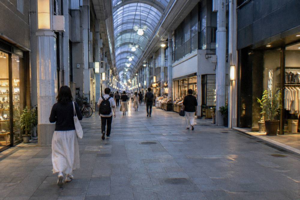 A lit shopping arcade in central Hiroshima in the evening with a few pedestrians