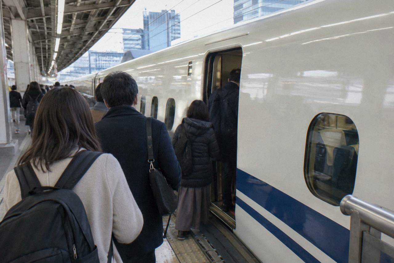 Passengers on the platform beside a white Tokaido shinkansen at Tokyo Station