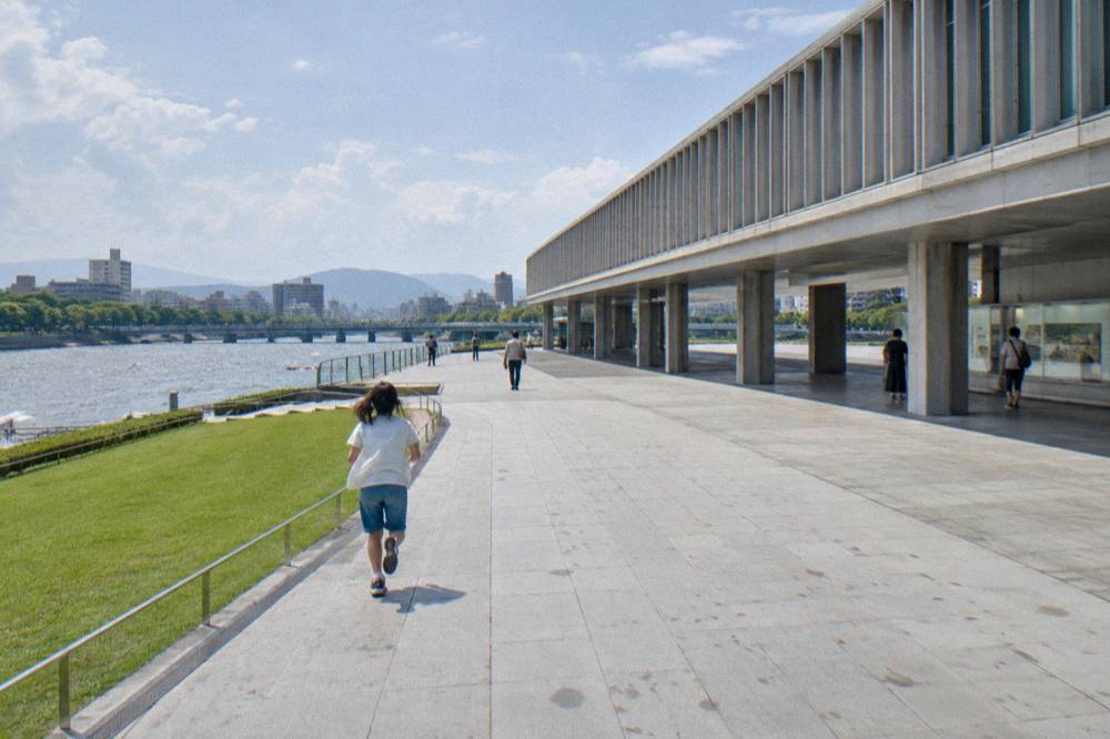 Exhibits inside the Hiroshima Peace Memorial Museum, with visitors viewing displays in soft light.