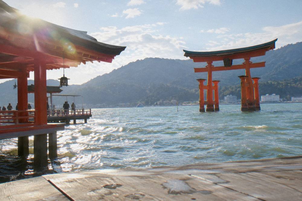 The great torii of Itsukushima Shrine standing in shallow water at high tide on Miyajima island.