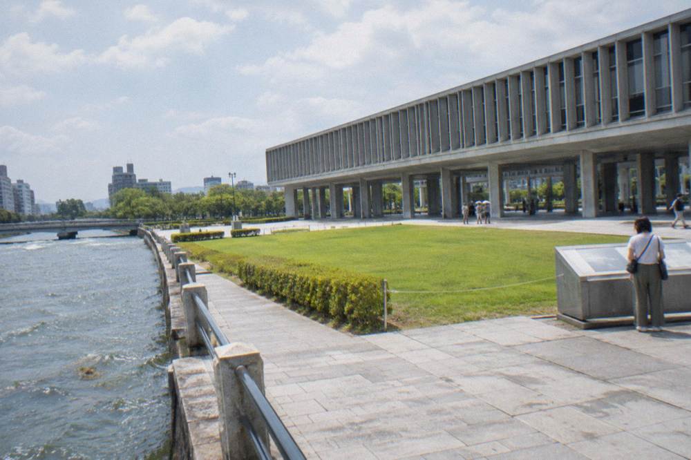 Visitors stand before an exhibit inside the Hiroshima Peace Memorial Museum, reading quietly.