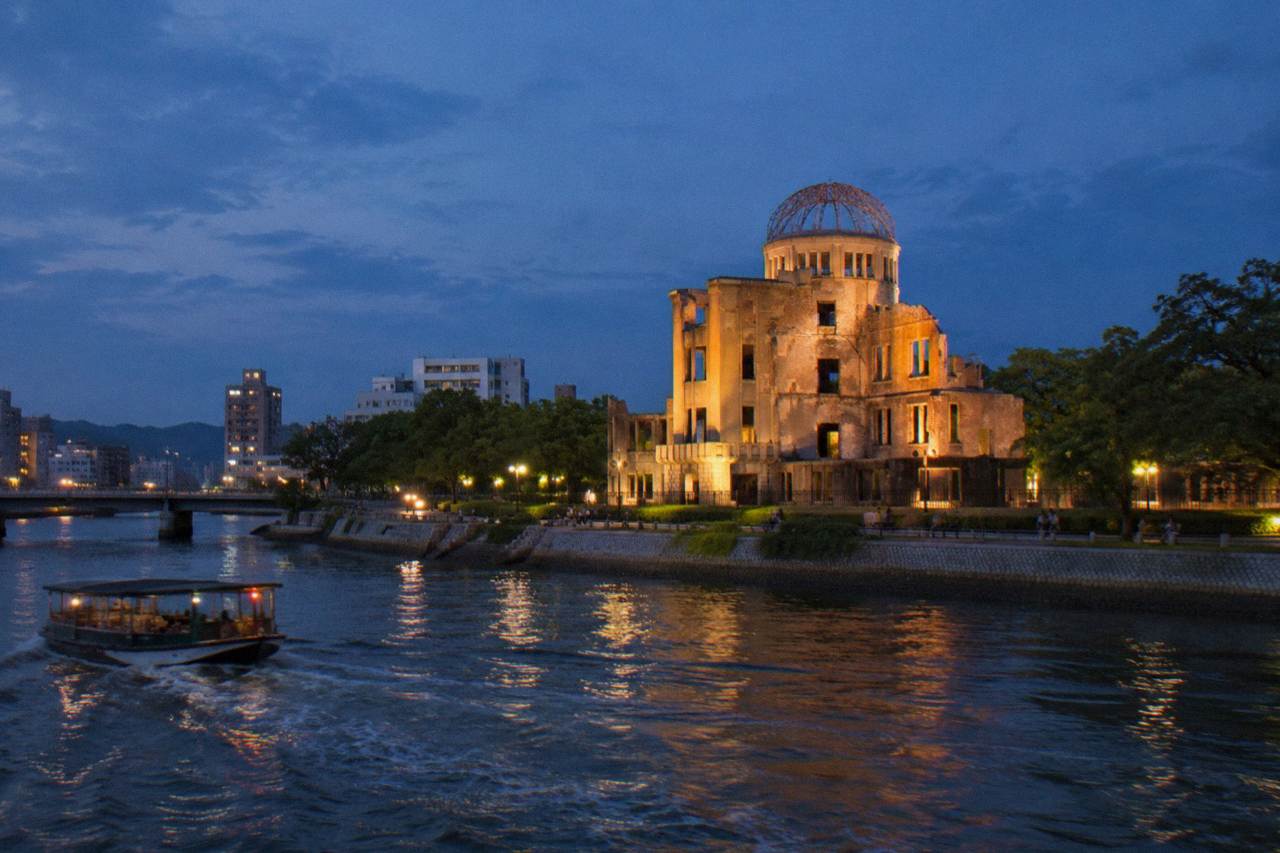 The Atomic Bomb Dome in Hiroshima illuminated at night, seen across the Motoyasu River