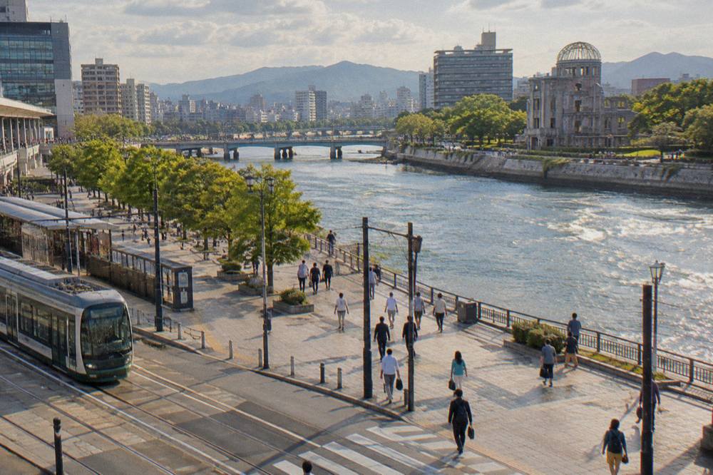 Visitors walking along the Motoyasu River toward the A-Bomb Dome in Hiroshima
