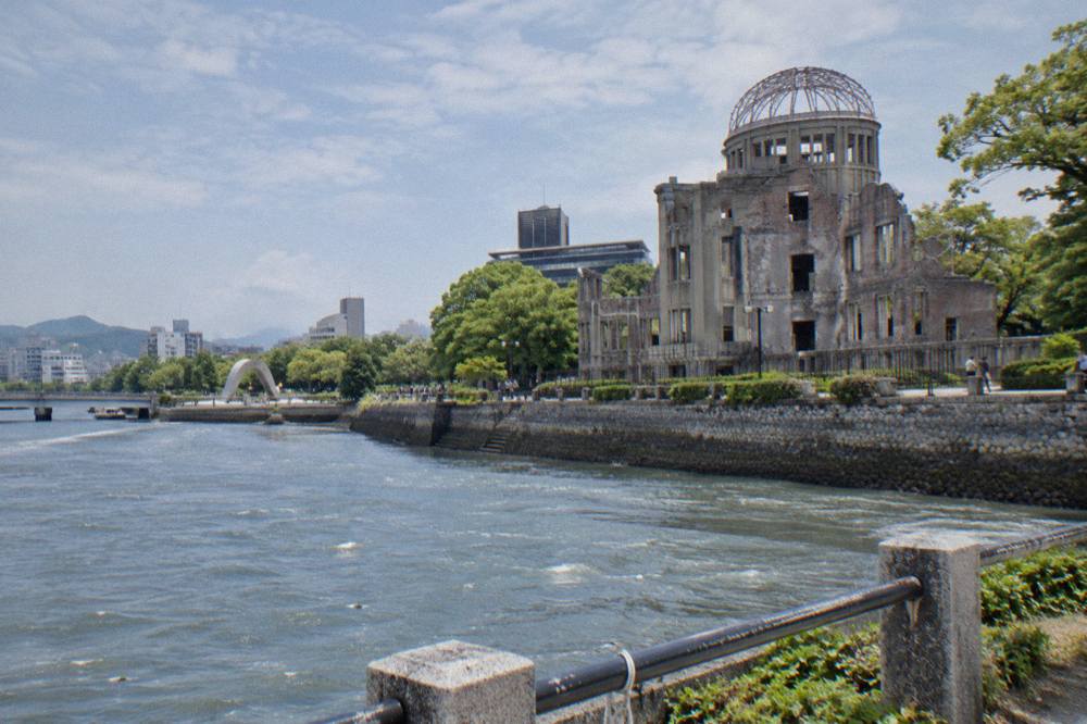 The Peace Memorial Park in Hiroshima with the cenotaph and flame framing the A-Bomb Dome across the river