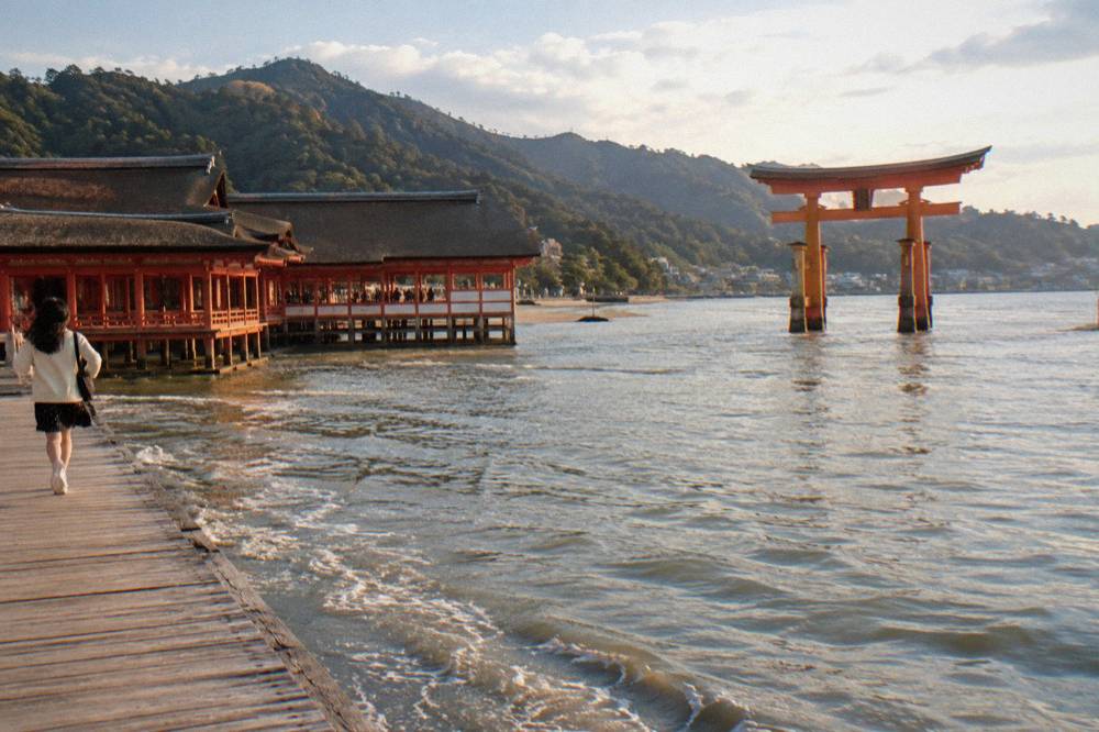The Great Torii of Itsukushima Shrine standing in the shallows at Miyajima with the shrine buildings beyond