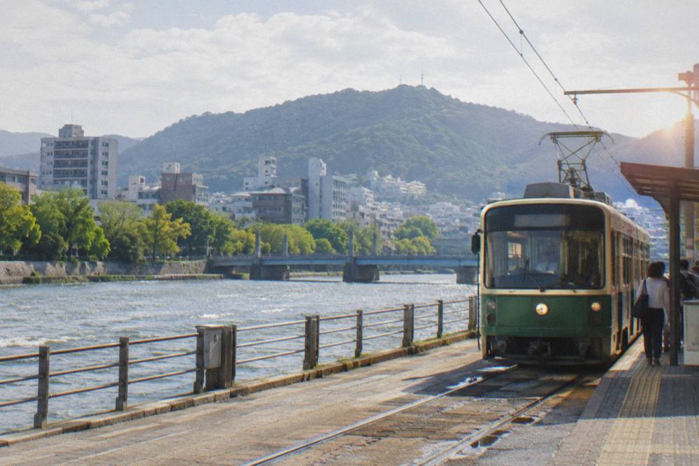 A Hiroden green streetcar arriving at a stop in central Hiroshima
