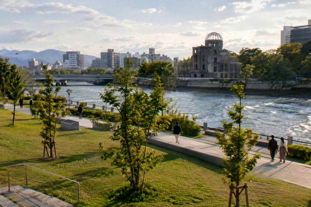 The Peace Memorial Park lawn in Hiroshima with the A-Bomb Dome beyond the river