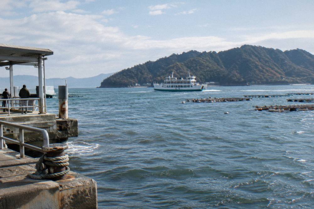 A JR ferry crossing the water between Miyajimaguchi and Miyajima island on a clear day